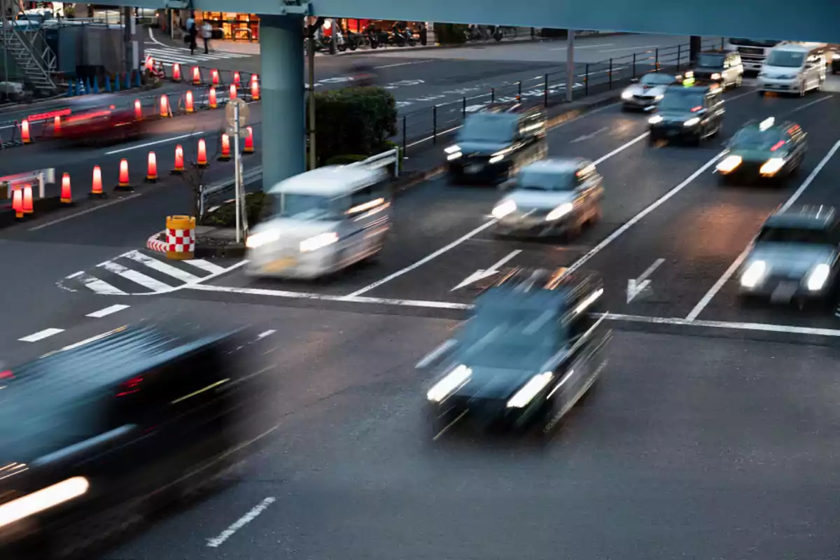 Tráfico de autos en movimiento en una avenida urbana durante el atardecer Tráfico de autos en movimiento en una avenida urbana durante el atardecer