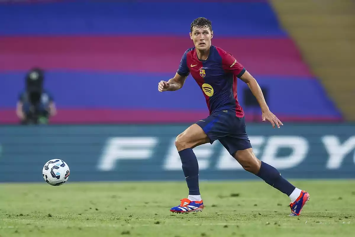 Futbolista del FC Barcelona con uniforme azul y rojo corriendo en el campo durante un partido con un balón cerca Futbolista del FC Barcelona con uniforme azul y rojo corriendo en el campo durante un partido con un balón cerca