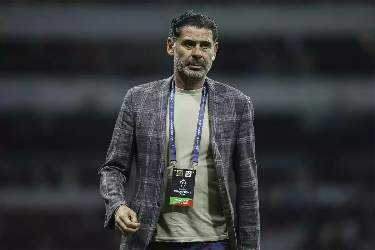 Dark-haired, bearded man wearing a plaid jacket and an all-access badge in a stadium Dark-haired, bearded man wearing a plaid jacket and an all-access badge in a stadium