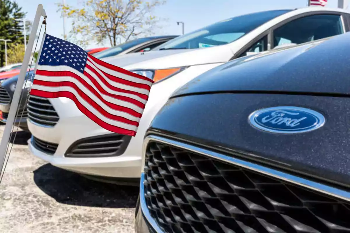 Autos Ford estacionados junto a una bandera de Estados Unidos ondeando