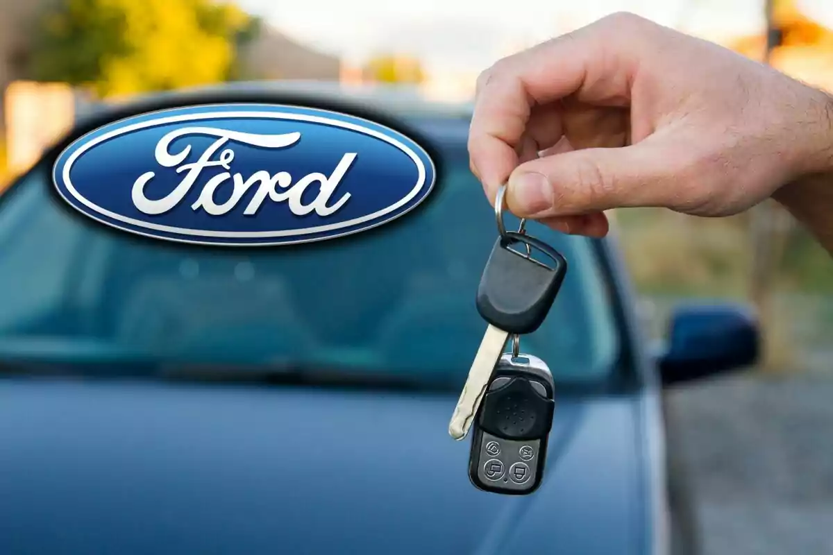A hand holds car keys in front of a vehicle with the Ford logo in the foreground. A hand holds car keys in front of a vehicle with the Ford logo in the foreground.