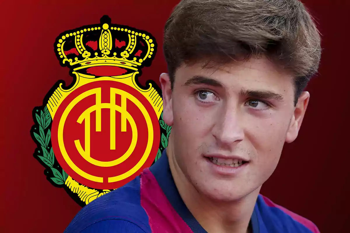 Joven con camiseta azul y roja frente al escudo del Real Mallorca sobre fondo rojo