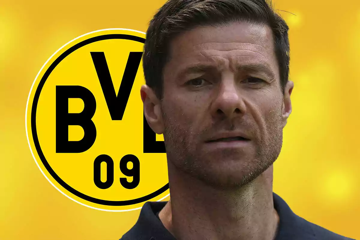 Un hombre de cabello corto y barba frente al escudo amarillo y negro del Borussia Dortmund
