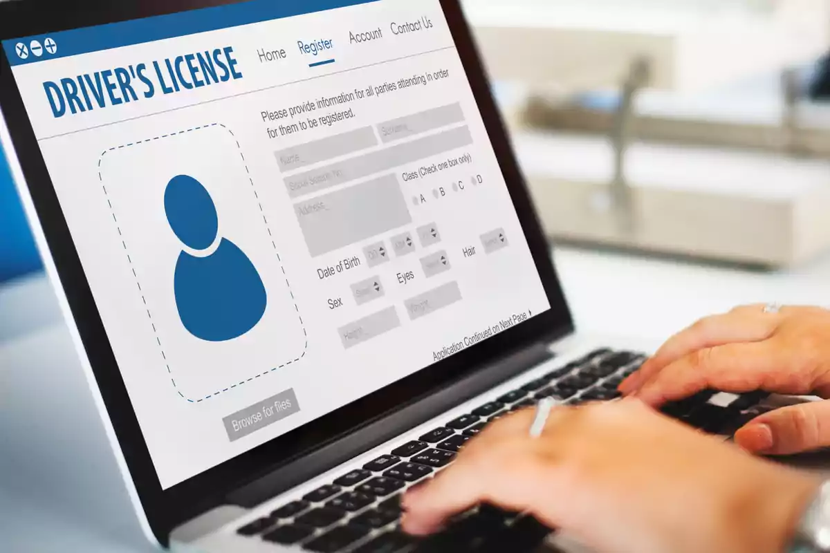 Person using a laptop to fill out an online driver’s license application form Person using a laptop to fill out an online driver’s license application form