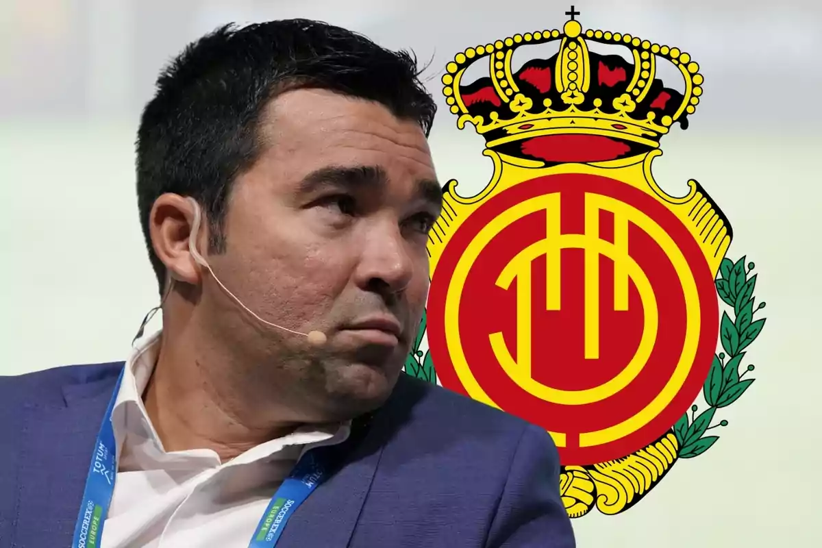 Hombre con micrófono de diadema y chaqueta azul frente al escudo del Real Mallorca