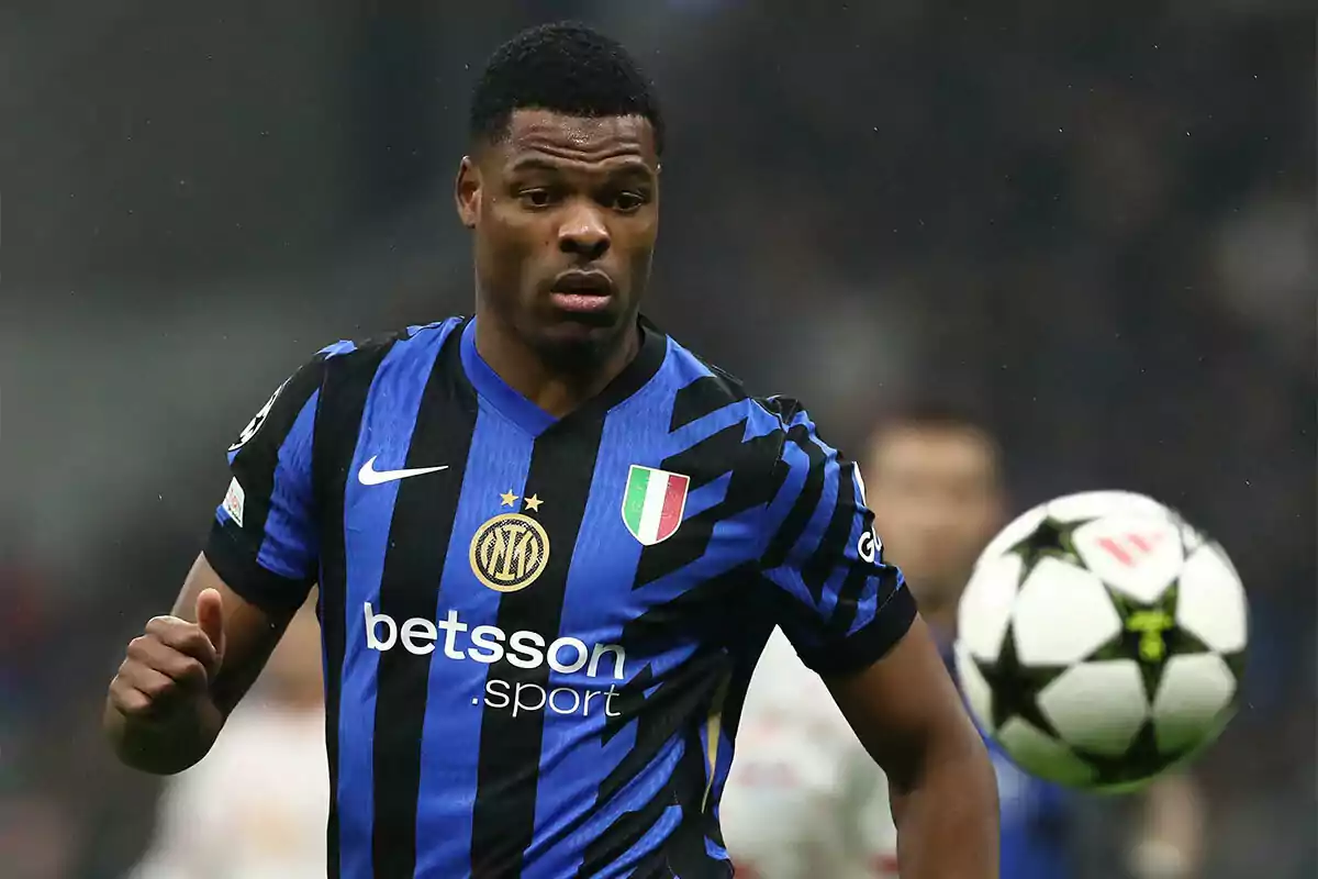 Inter Milan player in a blue and black uniform watching a ball during a match