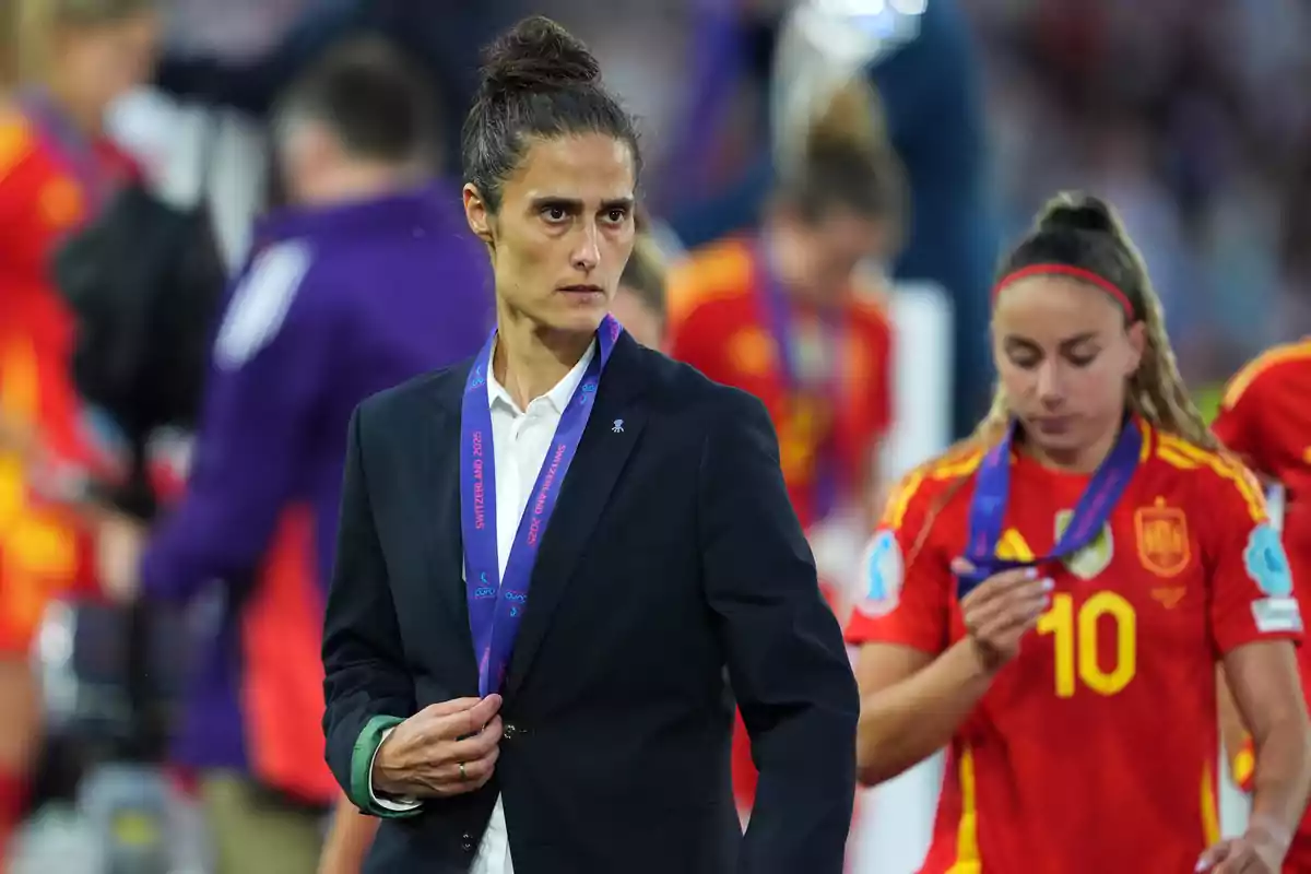 Coach and players of the Spanish women's national soccer team with medals and serious expressions after a match