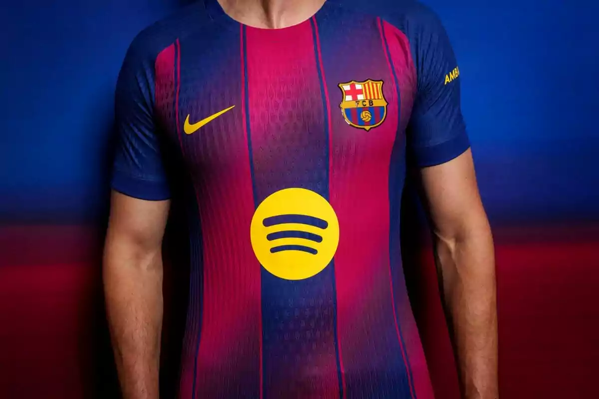 Person wearing the FC Barcelona jersey with blue and garnet colors, the Nike logo, the club crest, and Spotify sponsorship in the center