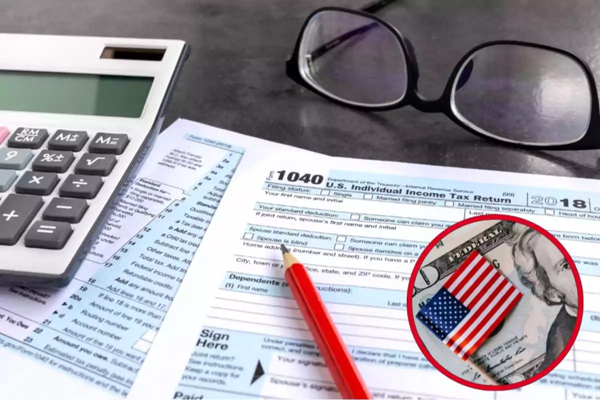 Formulario de impuestos estadounidense 1040 junto a una calculadora, un lápiz rojo y unos lentes sobre una mesa, con un billete y una pequeña bandera de Estados Unidos en primer plano Formulario de impuestos estadounidense 1040 junto a una calculadora, un lápiz rojo y unos lentes sobre una mesa, con un billete y una pequeña bandera de Estados Unidos en primer plano