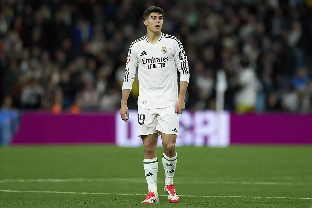 Jugador del Real Madrid con uniforme blanco en el campo de fútbol durante un partido Jugador del Real Madrid con uniforme blanco en el campo de fútbol durante un partido