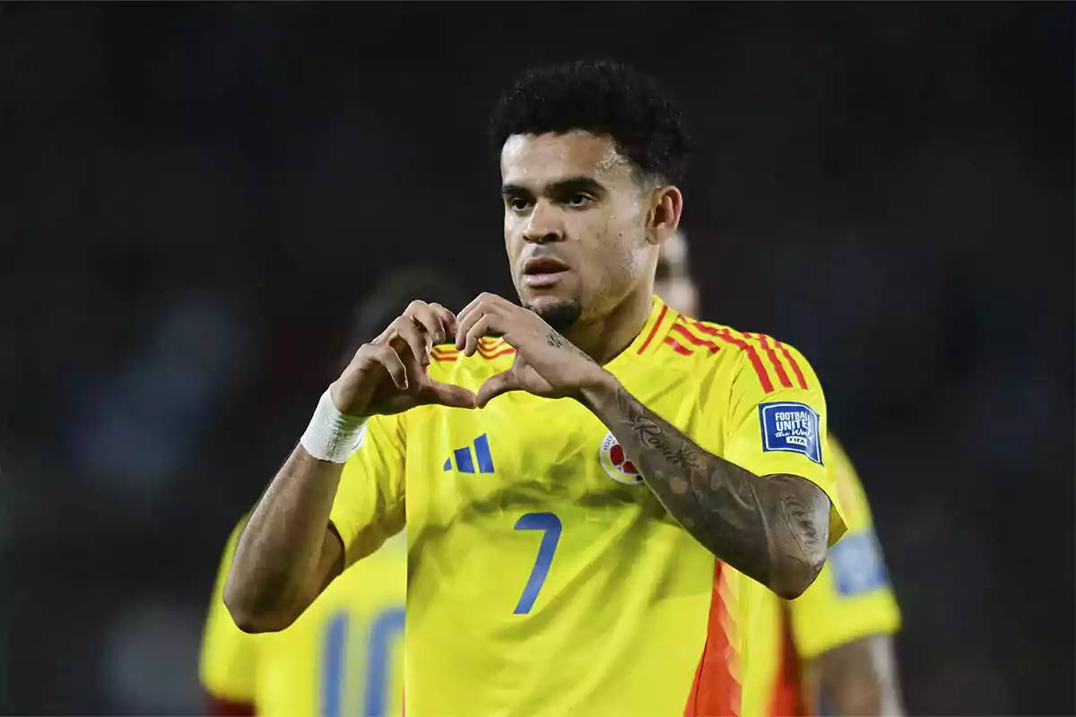 Futbolista con uniforme amarillo de la selección de Colombia haciendo un gesto de corazón con las manos durante un partido Futbolista con uniforme amarillo de la selección de Colombia haciendo un gesto de corazón con las manos durante un partido