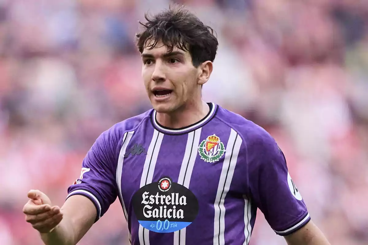 Mario Martín in a purple Real Valladolid uniform gesturing during a match. Mario Martín in a purple Real Valladolid uniform gesturing during a match.