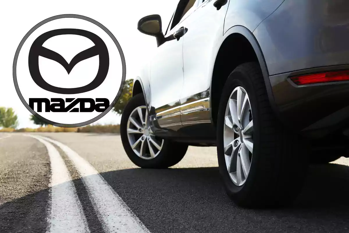 Auto Mazda gris sobre una carretera con el logo de Mazda en la esquina izquierda Auto Mazda gris sobre una carretera con el logo de Mazda en la esquina izquierda