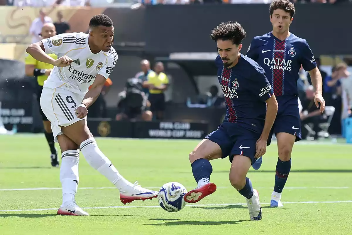 A Real Madrid player tries to shoot at the goal while a PSG defender blocks the ball during a soccer match. A Real Madrid player tries to shoot at the goal while a PSG defender blocks the ball during a soccer match.