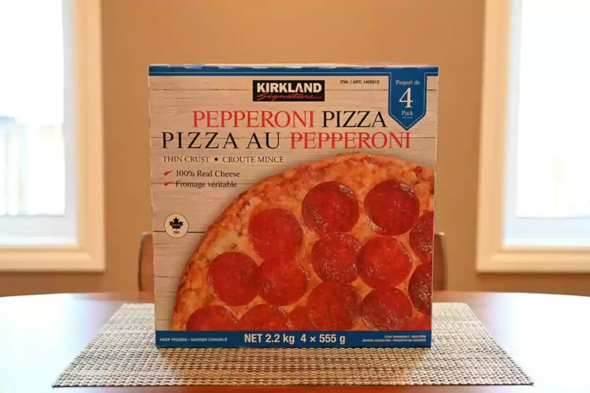 Caja de pizza de pepperoni Kirkland Signature sobre una mesa con fondo de ventanas y paredes beige Caja de pizza de pepperoni Kirkland Signature sobre una mesa con fondo de ventanas y paredes beige
