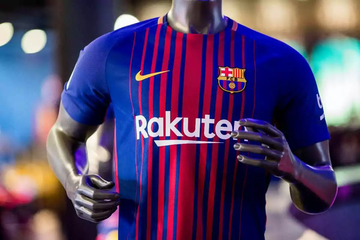 Maniquí vistiendo una camiseta azul y roja del FC Barcelona con el logo de Nike y el patrocinio de Rakuten Maniquí vistiendo una camiseta azul y roja del FC Barcelona con el logo de Nike y el patrocinio de Rakuten