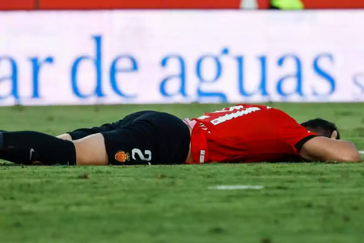 Soccer player lying face down on the grass during a match Soccer player lying face down on the grass during a match