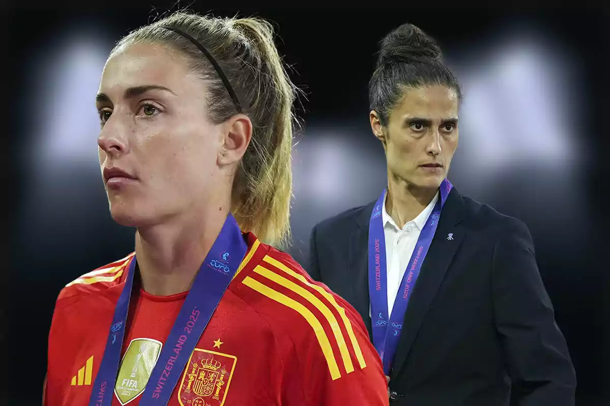 Two women with medals and serious expressions, one wearing the red uniform of the Spanish national soccer team and the other in a dark suit, both against a blurred dark background.