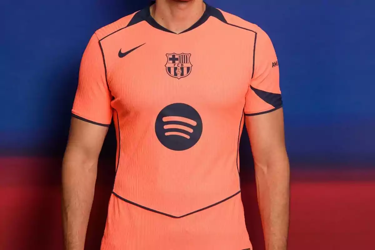 Persona vistiendo una camiseta naranja del FC Barcelona con detalles en azul marino y el logo de Spotify en el centro
