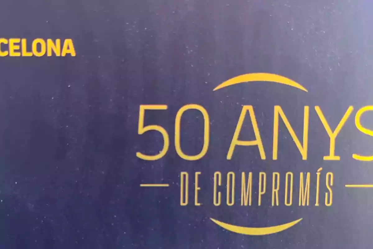 Catalan text on a dark blue background that says 50 years of commitment in yellow letters Catalan text on a dark blue background that says 50 years of commitment in yellow letters