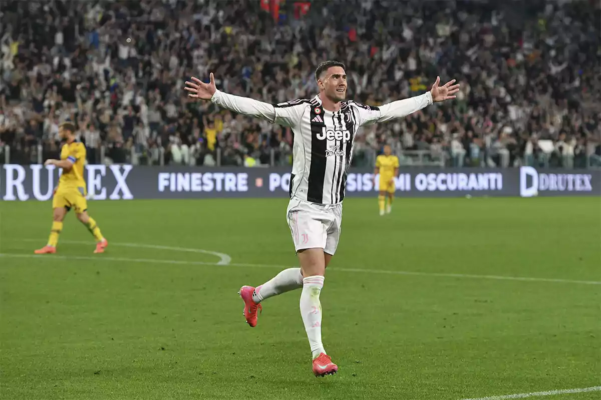 Futbolista de la Juventus celebrando un gol con los brazos abiertos en un estadio lleno de aficionados Futbolista de la Juventus celebrando un gol con los brazos abiertos en un estadio lleno de aficionados