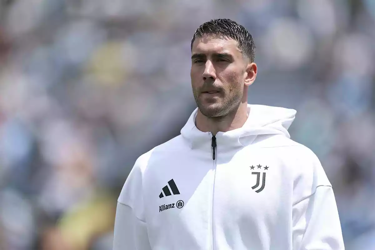 Jugador de fútbol con chaqueta blanca de la Juventus en un estadio desenfocado Jugador de fútbol con chaqueta blanca de la Juventus en un estadio desenfocado