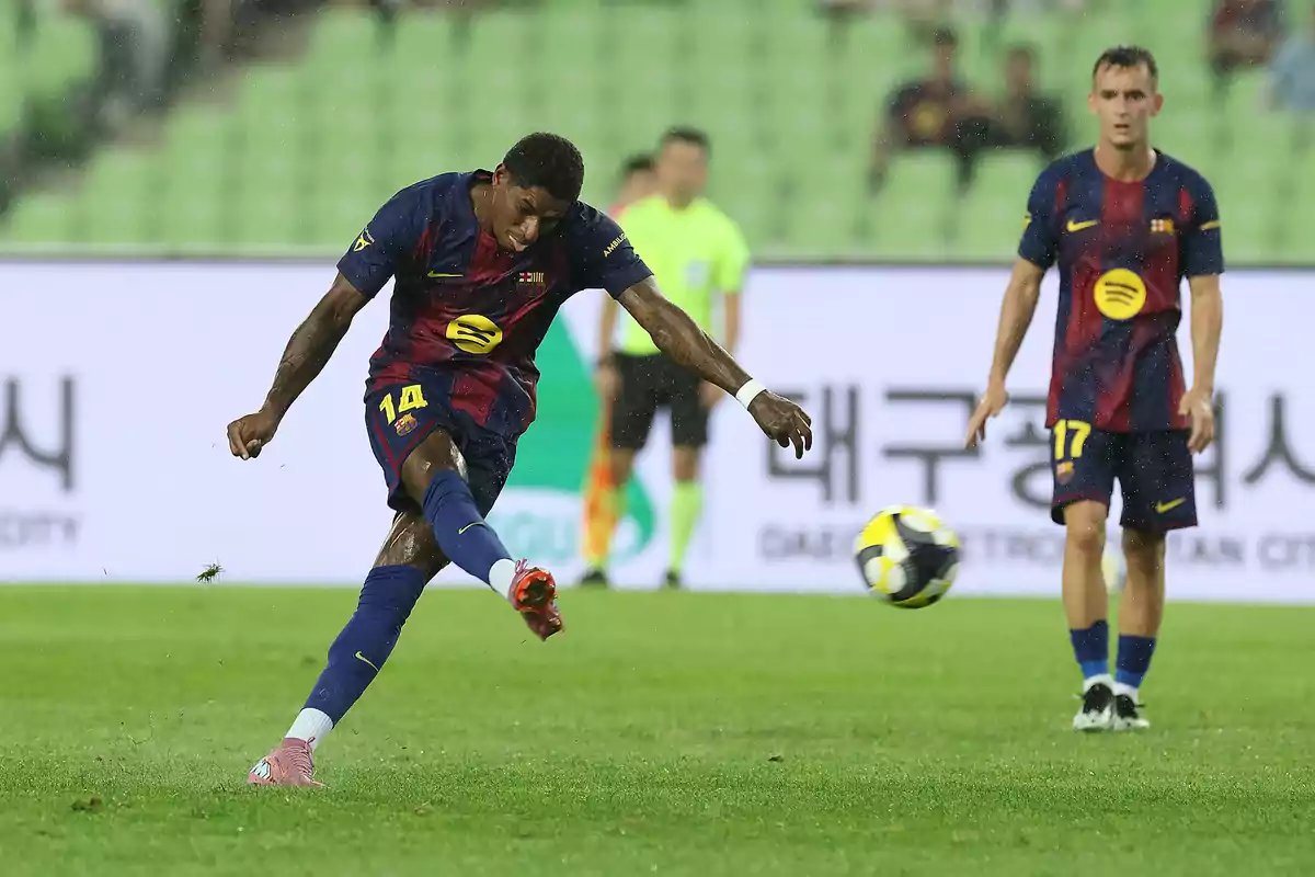 Futbolista del Barcelona dispara el balón durante un partido mientras otro jugador observa en el campo