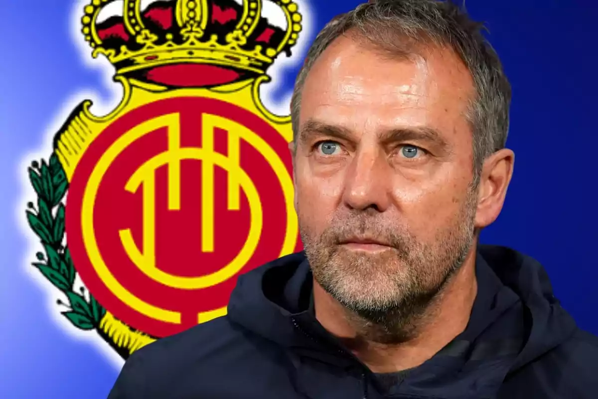 Hombre de cabello corto y barba con expresión seria frente al escudo del club de fútbol Mallorca