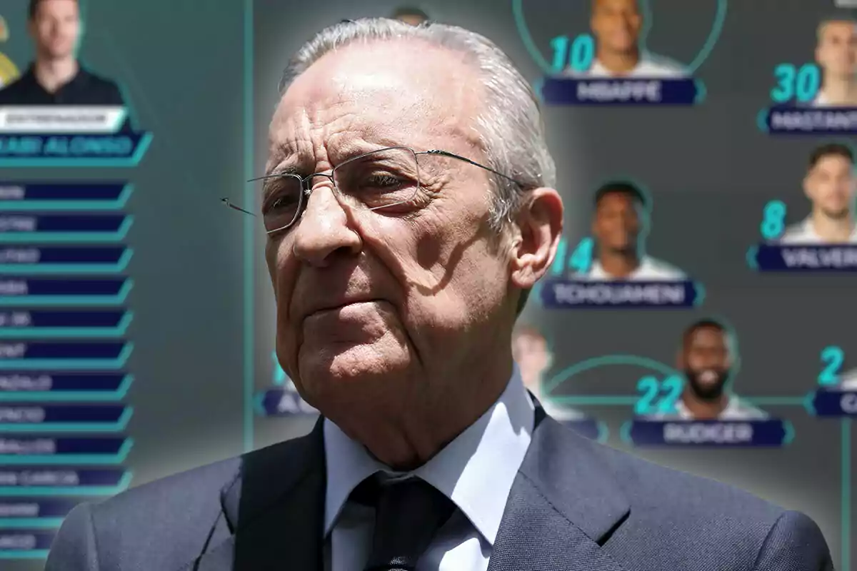 Older man with gray hair and glasses, wearing a dark suit and a serious expression, standing in front of a blurred background with graphics and photos of players.