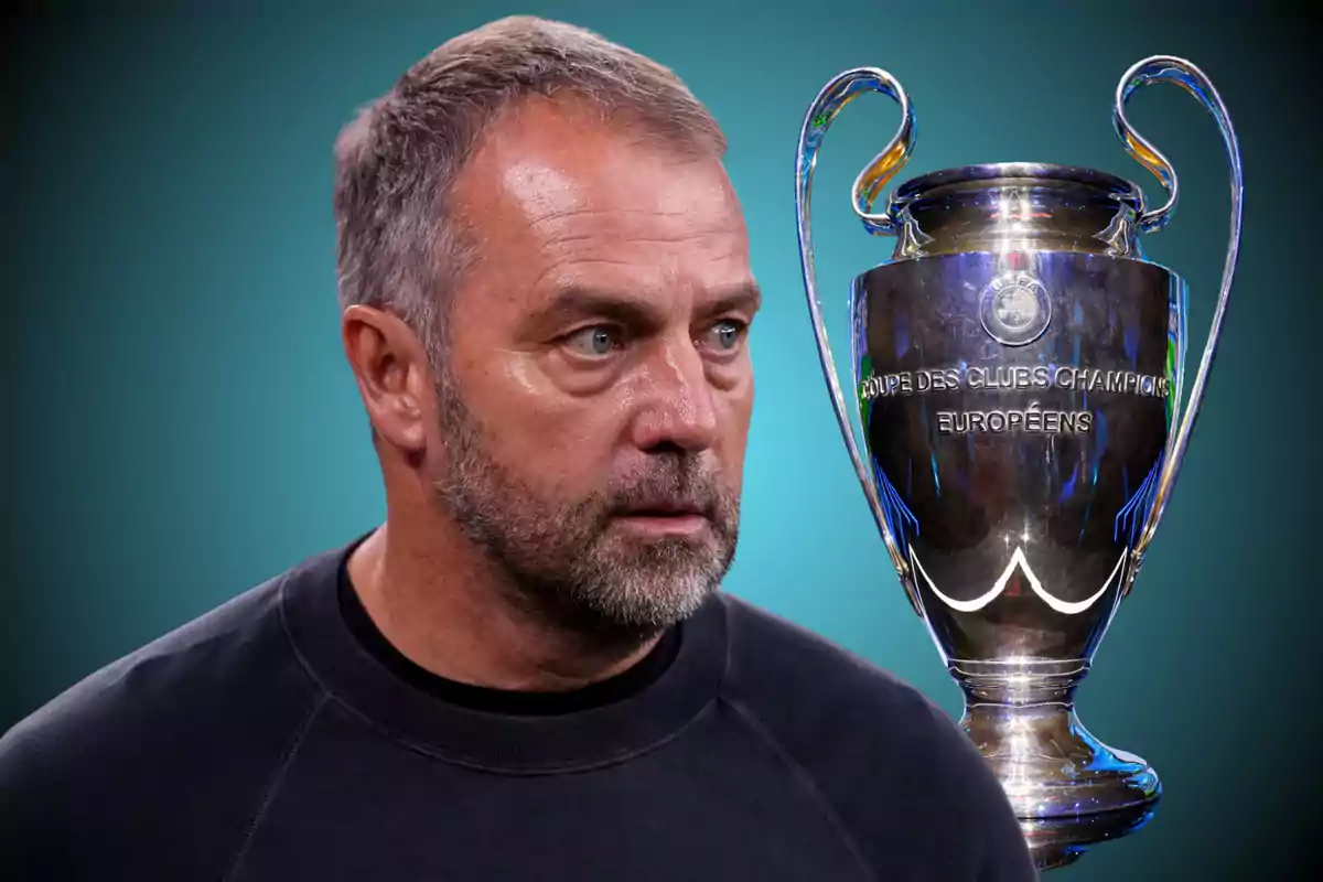 Short-haired, bearded man looking to the right with the Champions League trophy next to him against a blue background