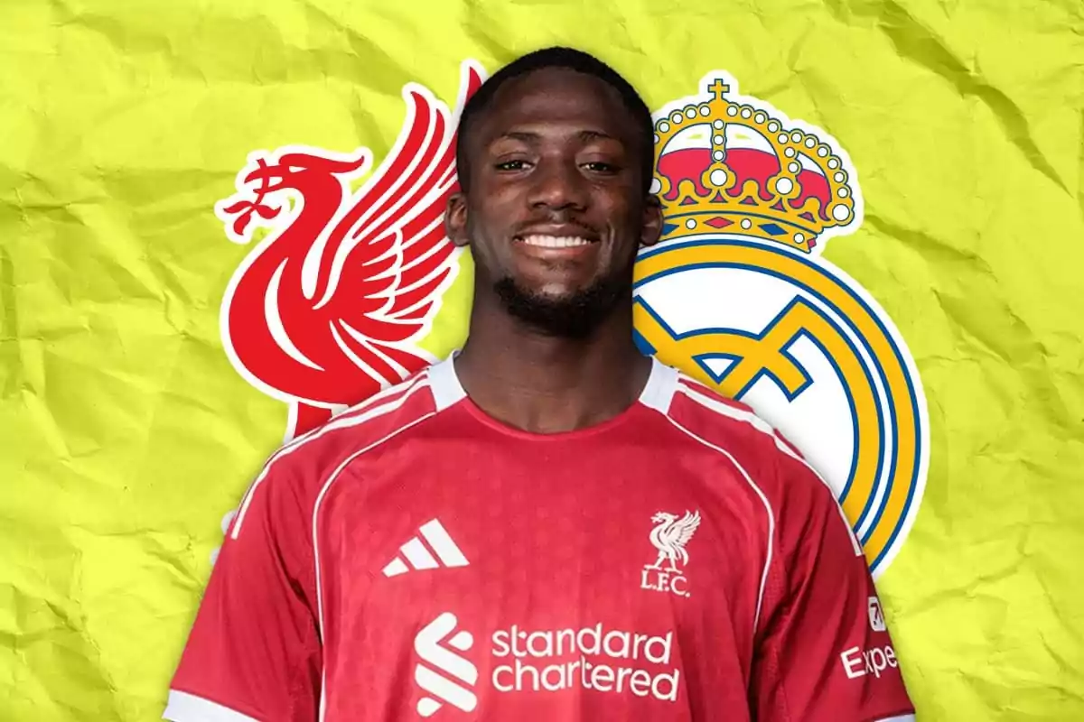Futbolista con camiseta del Liverpool sonríe frente a los escudos de Liverpool y Real Madrid sobre un fondo amarillo