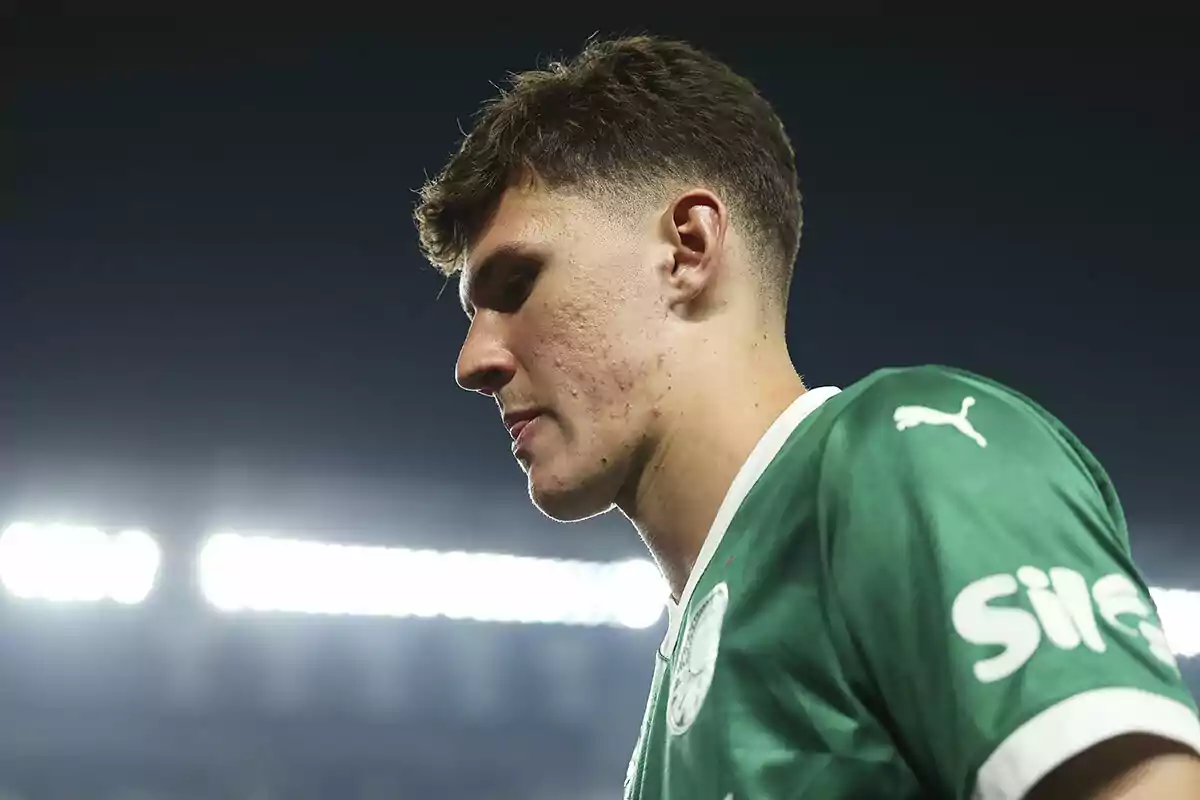 Joven futbolista con camiseta verde de Puma en un estadio iluminado Joven futbolista con camiseta verde de Puma en un estadio iluminado