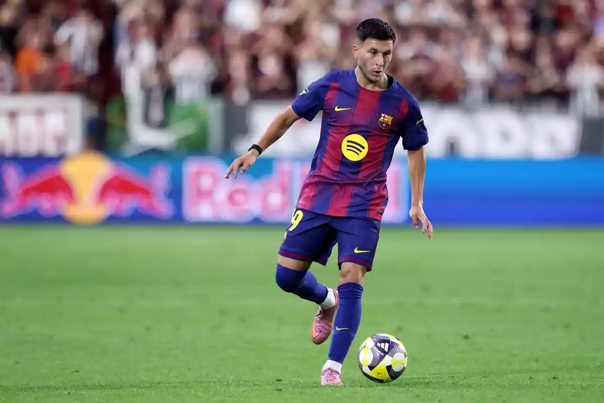 FC Barcelona player controlling the ball during a match in a stadium full of fans FC Barcelona player controlling the ball during a match in a stadium full of fans
