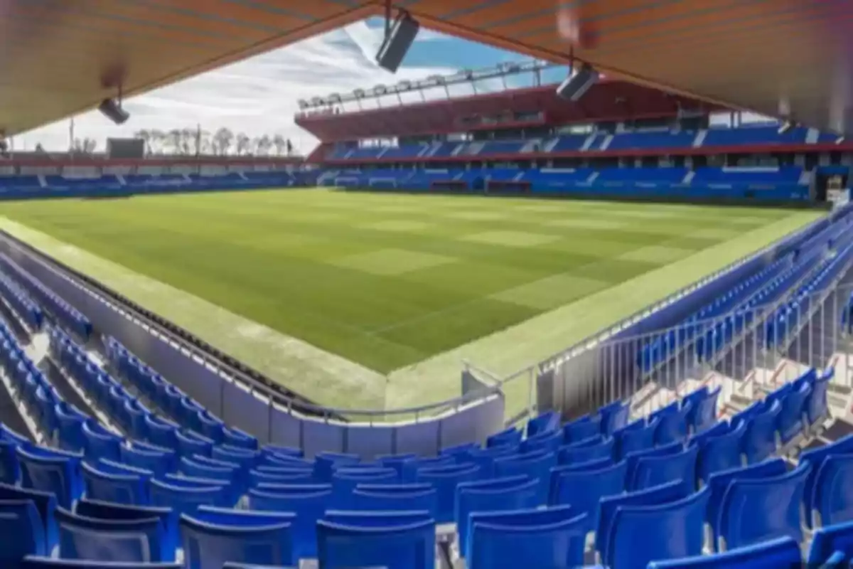 Empty soccer stadium with blue stands and a well-maintained grass field seen from one of the corners Empty soccer stadium with blue stands and a well-maintained grass field seen from one of the corners