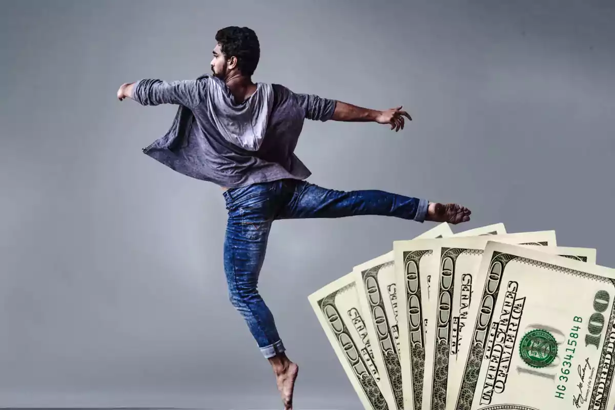 Young man dancing with hundred-dollar bills in the foreground Young man dancing with hundred-dollar bills in the foreground