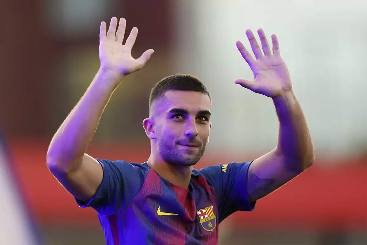 Jugador del FC Barcelona con los brazos levantados saludando al público en un estadio Jugador del FC Barcelona con los brazos levantados saludando al público en un estadio