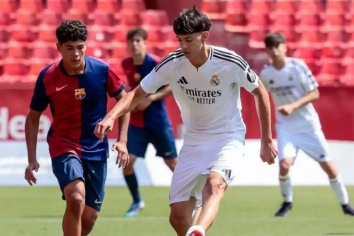 Youth players from the Real Madrid and Barcelona teams play a soccer match in a stadium with red stands. Youth players from the Real Madrid and Barcelona teams play a soccer match in a stadium with red stands.