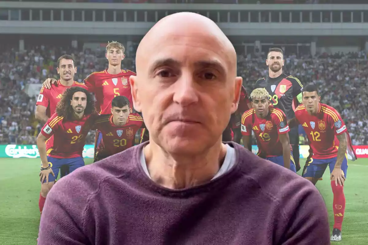 A bald man in the foreground with a serious expression, and in the background a group of players in red uniforms posing in a stadium full of spectators.