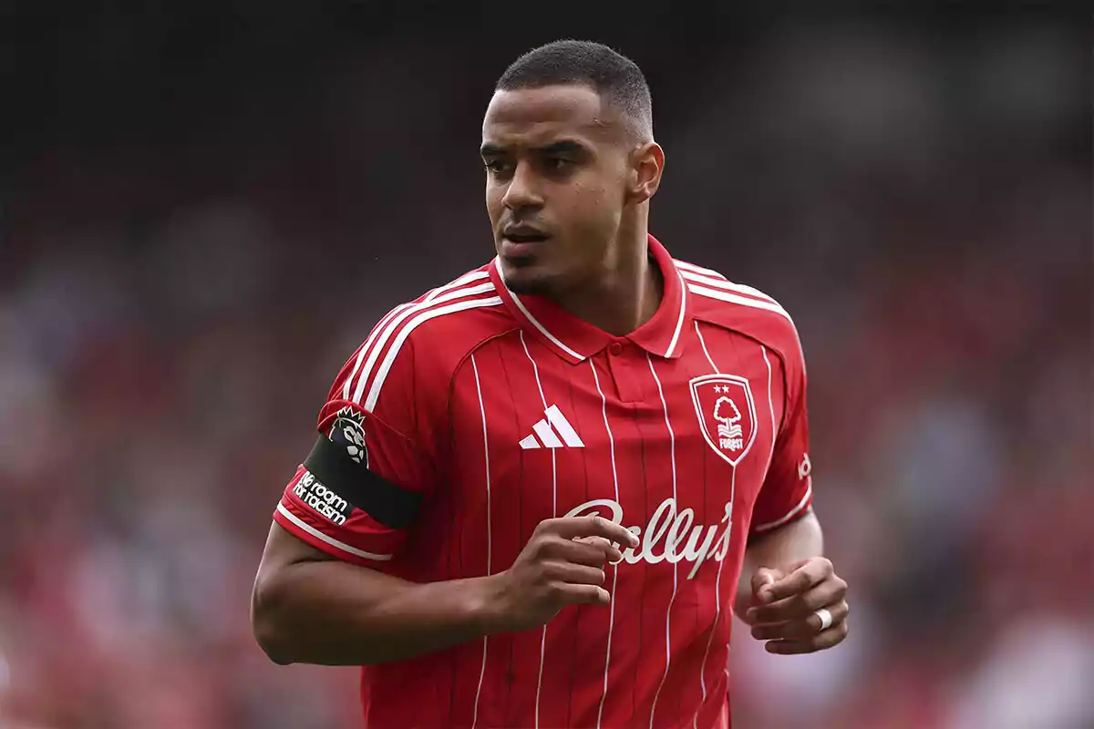 Soccer player in a red Nottingham Forest uniform during a match Soccer player in a red Nottingham Forest uniform during a match