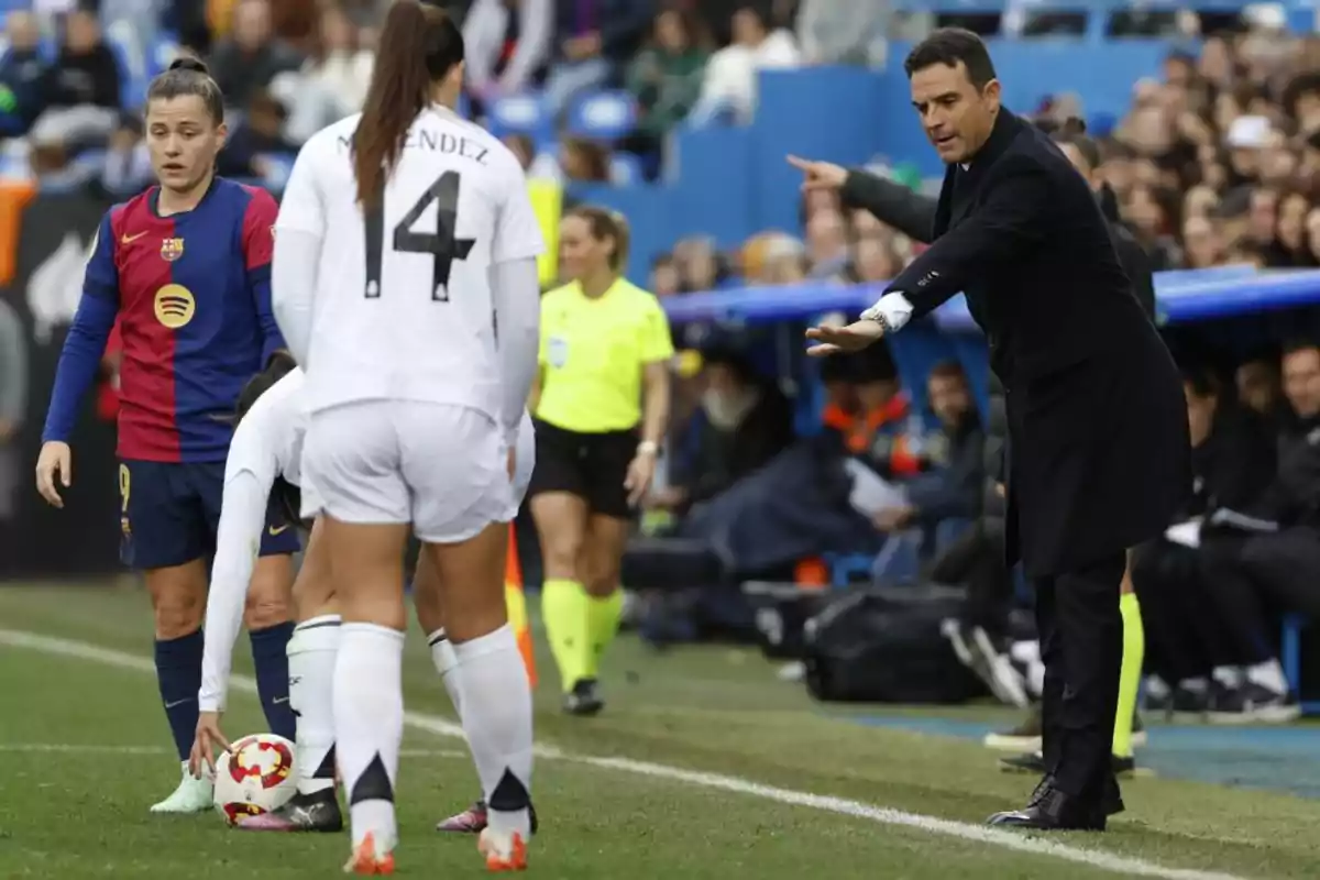 A coach gives instructions to female players on the field during a match. A coach gives instructions to female players on the field during a match.