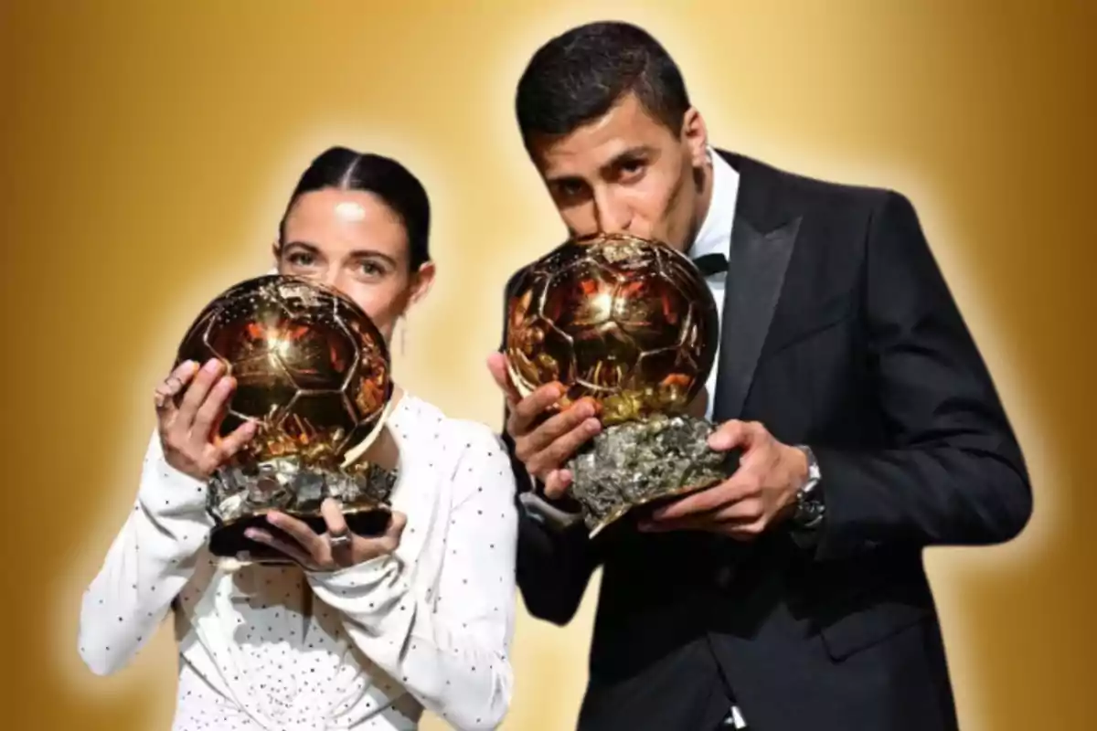 Dos personas sostienen trofeos dorados en un fondo dorado.