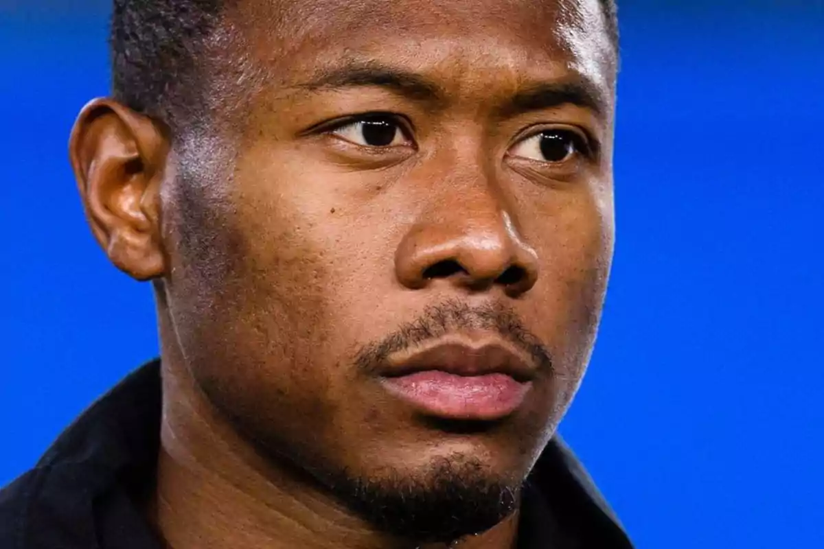 Close-up of a man with serious expression and blue background.