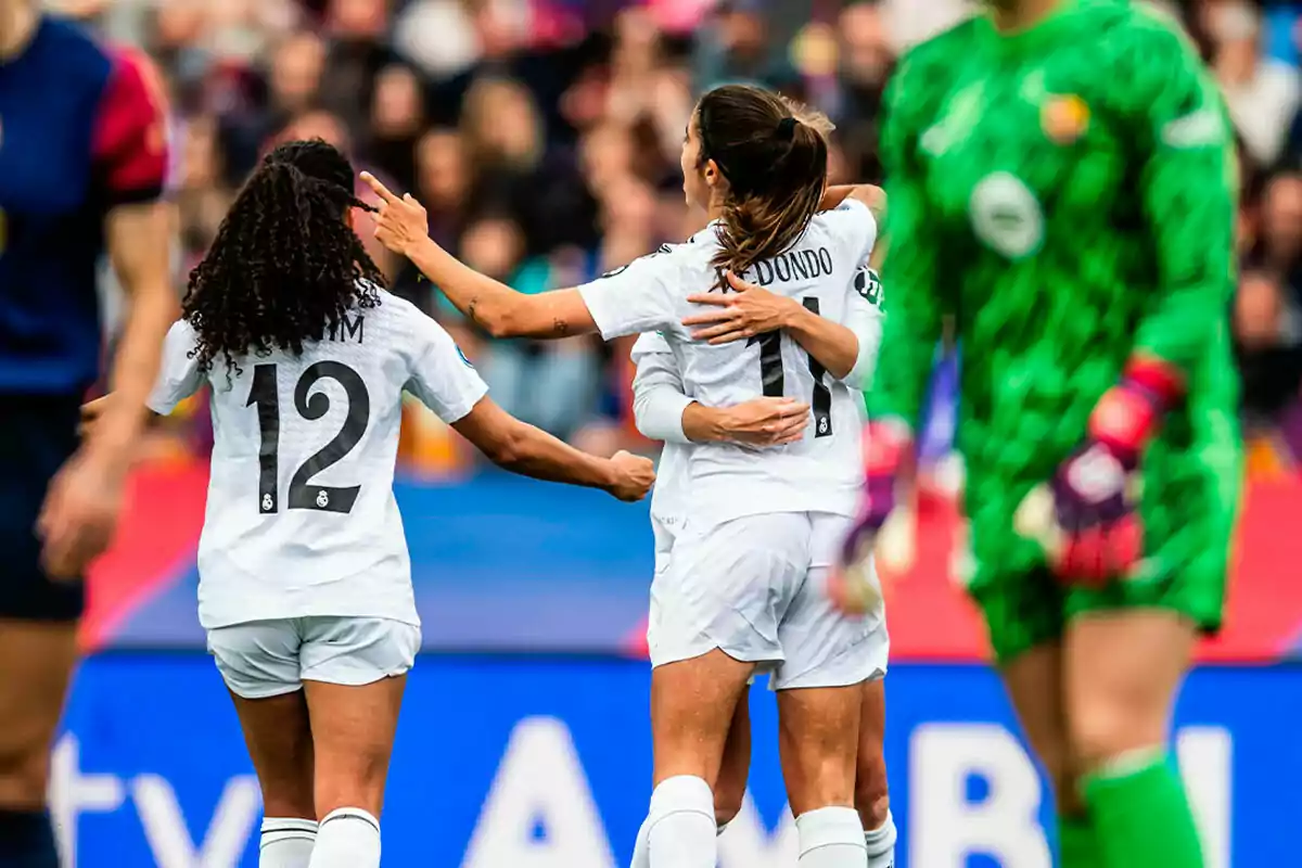 Jugadoras de fútbol celebrando un gol en el campo durante un partido.