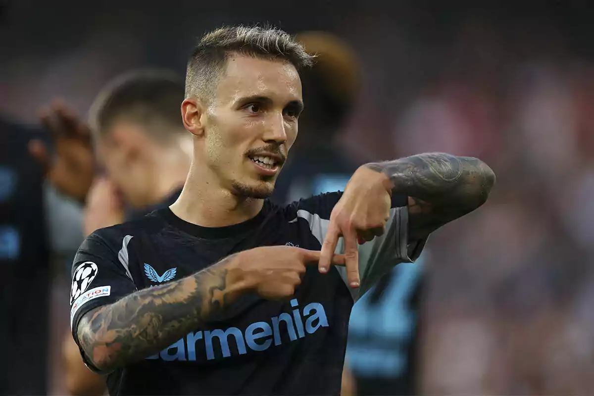 Soccer player celebrating a goal by making a hand gesture during a match