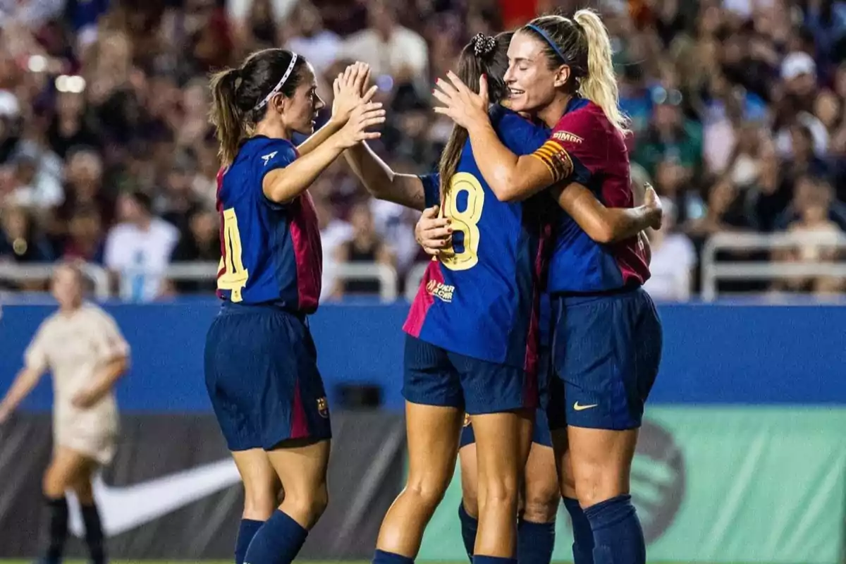 Jugadoras de fútbol celebrando un gol con un abrazo en el campo. Jugadoras de fútbol celebrando un gol con un abrazo en el campo.