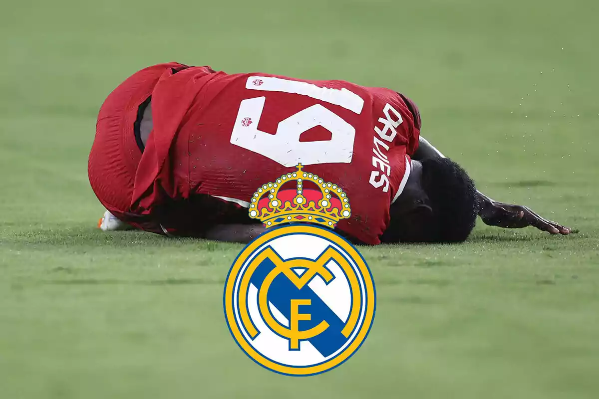 Alphonso Davies con camiseta roja tirado en el césped con el escudo del Real Madrid superpuesto.