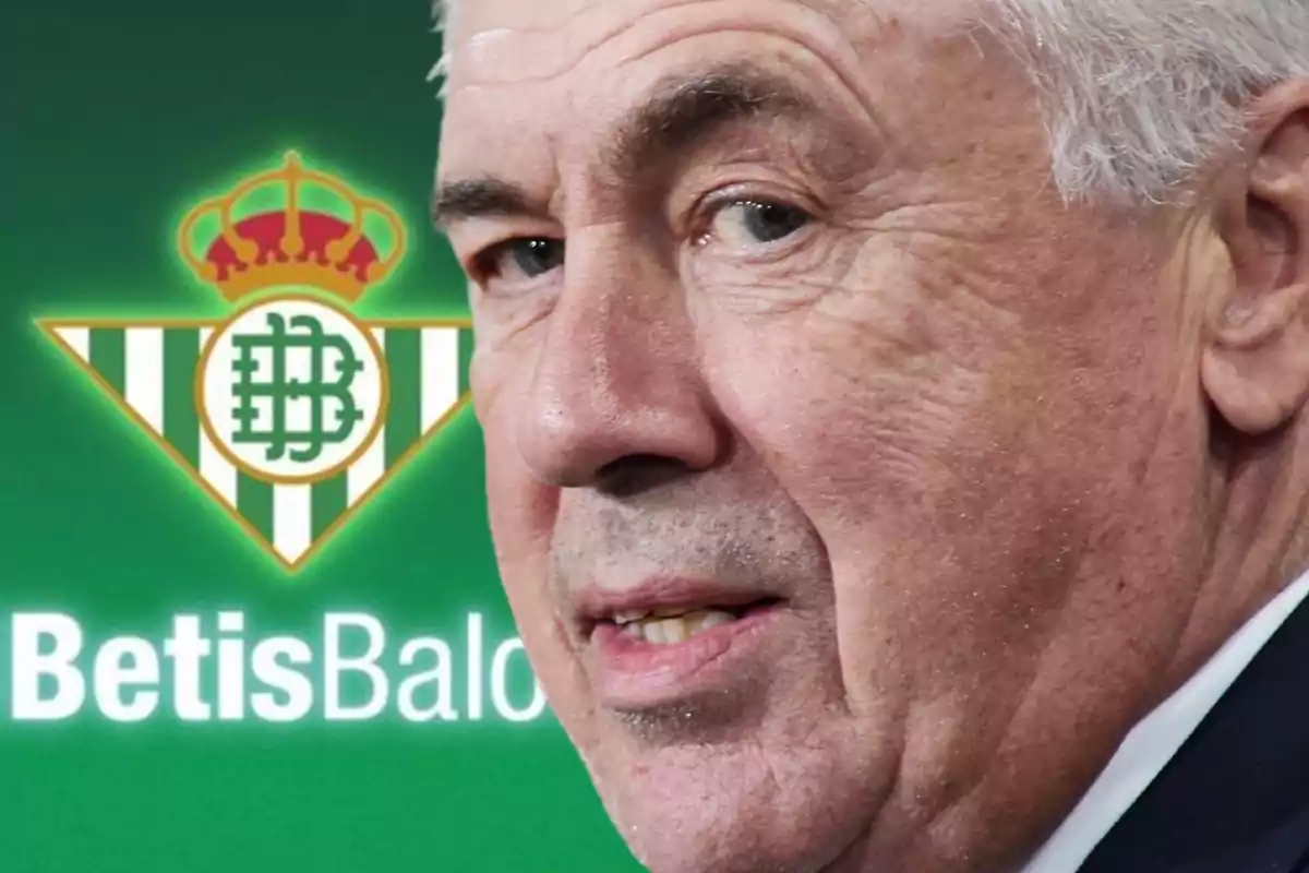 Older man with gray hair in front of the Real Betis Balompié logo.