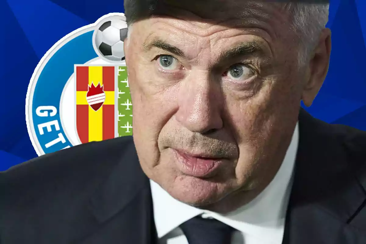 Carlo Ancelotti de traje con una expresión seria frente al escudo del Getafe.