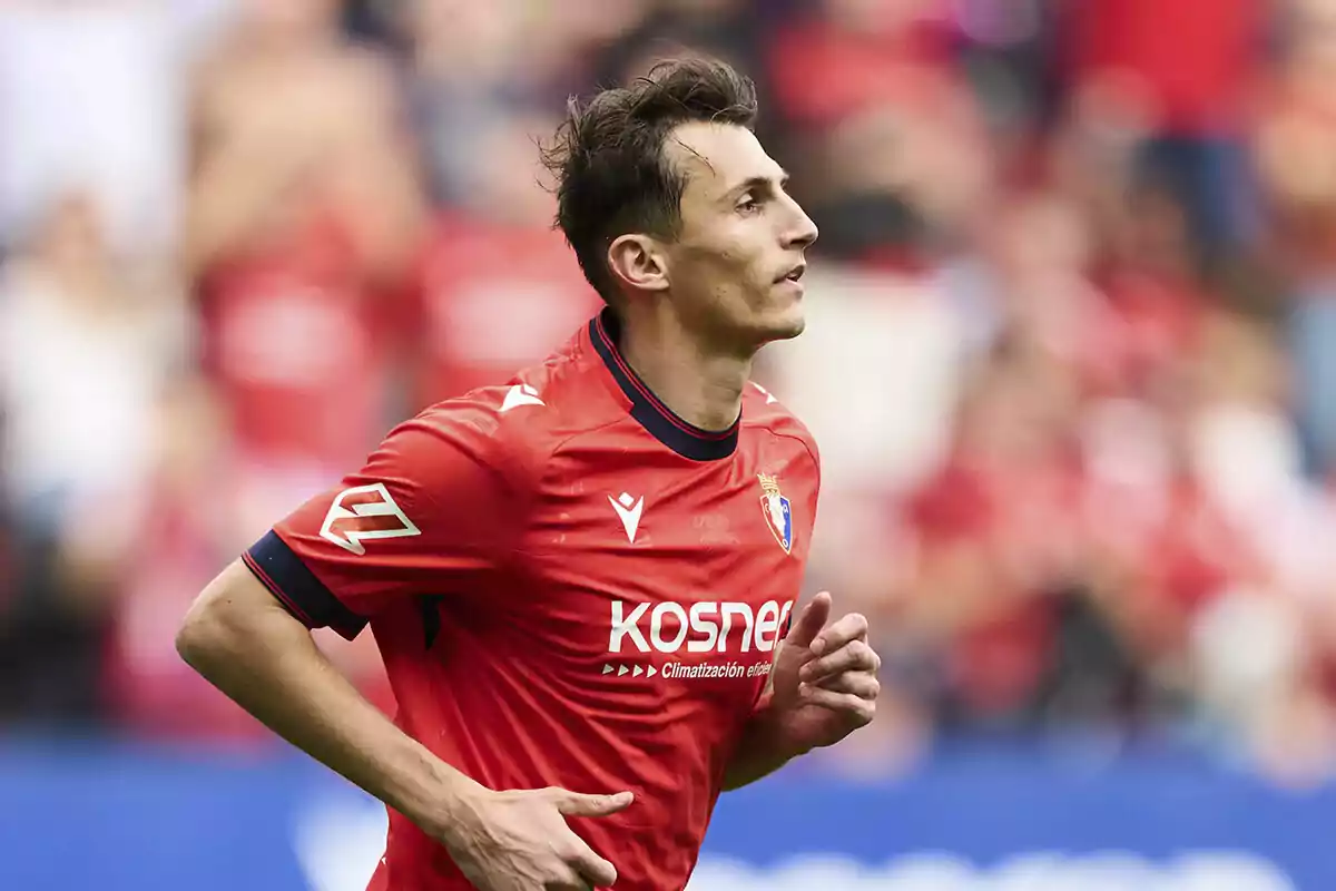 Soccer player wearing a red jersey running in a stadium during a match Soccer player wearing a red jersey running in a stadium during a match