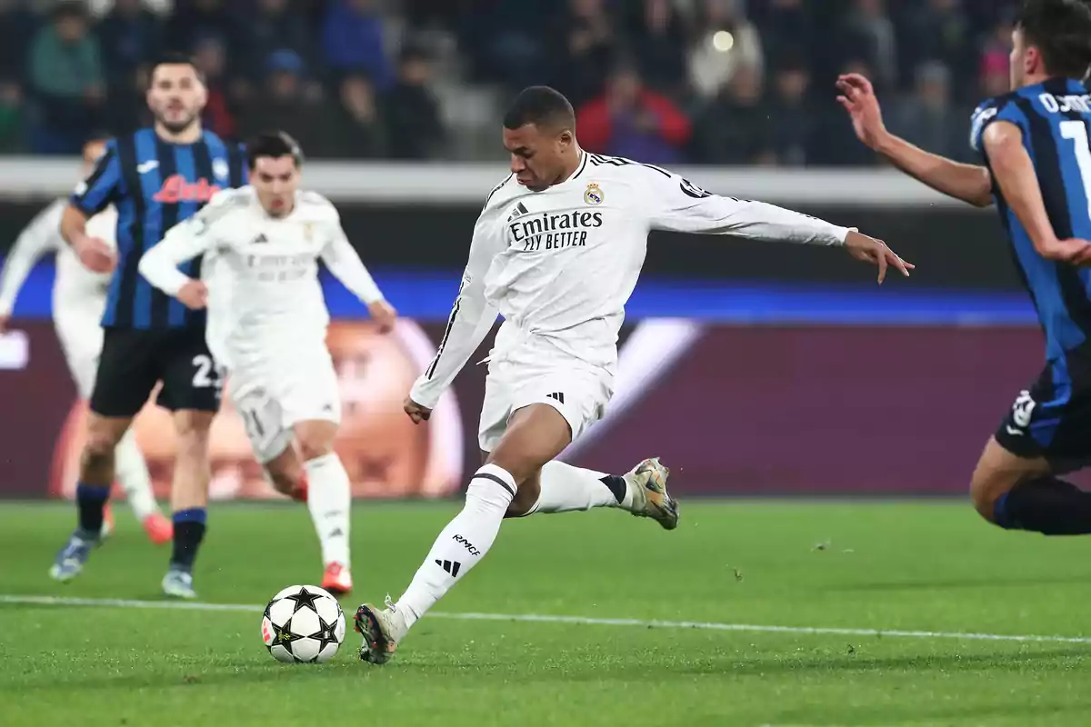 Soccer player in action during a match wearing white uniform while kicking the ball on the field. Soccer player in action during a match wearing white uniform while kicking the ball on the field.
